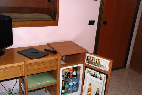 a room with a desk and a small refrigerator at Hotel Grillo Verde in Torre Annunziata
