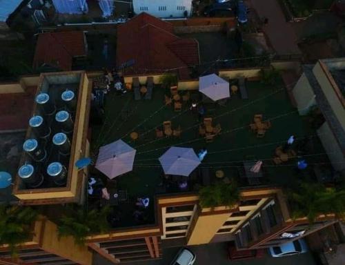 einen Blick über einen Garten mit Sonnenschirmen in der Unterkunft 2BHK Apartments in Kampala