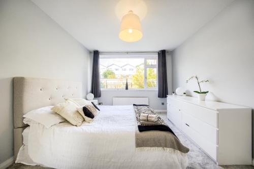 a white bedroom with a large bed and a window at Town Centre Apartment in Leamington Spa