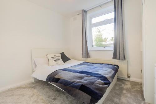 a small bedroom with a bed and a window at Town Centre Apartment in Leamington Spa