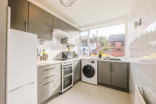 a kitchen with a washer and dryer and a window at Town Centre Apartment in Leamington Spa