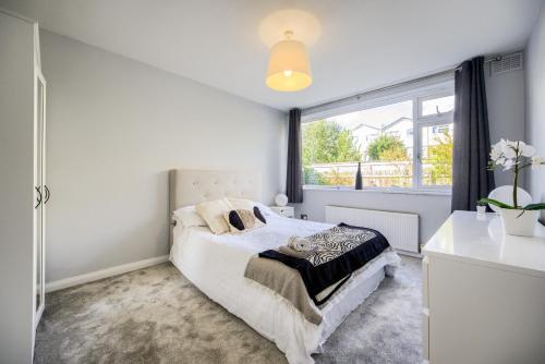 a white bedroom with a bed and a window at Town Centre Apartment in Leamington Spa