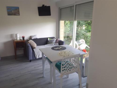 Maison d'hôtes indépendante à la campagne في Ablon: طاولة بيضاء وكراسي في غرفة المعيشة