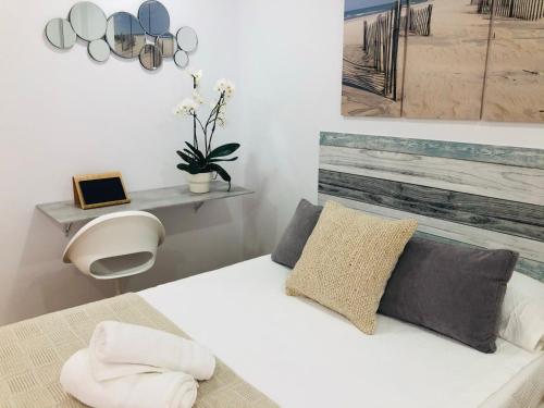 een slaapkamer met een wit bed met kussens bij Apartaestudio Moderno Benalmádena Málaga in Benalmádena