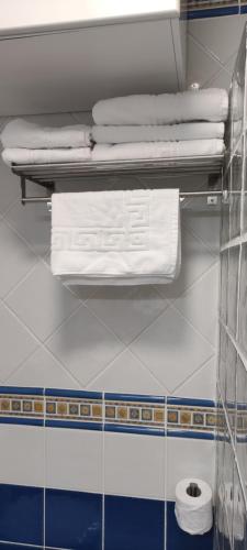 un estante con toallas blancas en el baño en Apartamento en icod de Los Vinos, playa San Marcos, en San Marcos