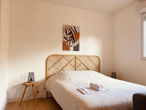 Un dormitorio con una cama con una toalla. en Appartement proche Hôpital et centre-ville en Saint Lo