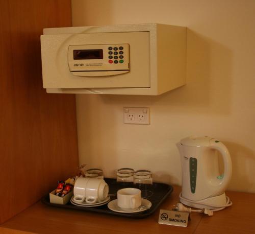 a kitchen with a coffee maker and a microwave at Garden Lodge Sydney Hotel in Sydney