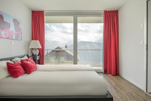 a bedroom with two beds and a large window at Bella Vista in Fieschertal