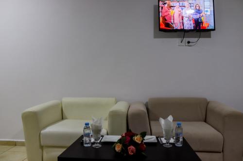 salon z kanapą, stołem i telewizorem w obiekcie HOTEL BORJ SAFAE LAAYOUNE w mieście Al-Ujun