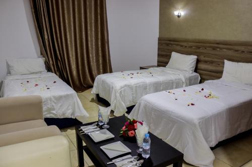 une chambre d'hôtel avec deux lits et un canapé dans l'établissement HOTEL BORJ SAFAE LAAYOUNE, à Laâyoune
