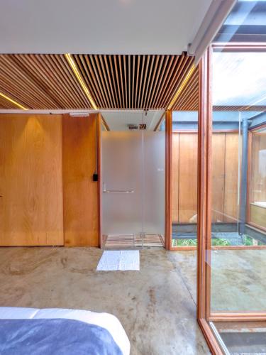a room with a bed and some glass doors at Deluxe volcán Primeras suites colgantes del mundo in Baños