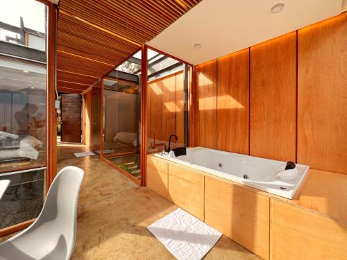 baño grande con bañera y silla en Deluxe volcán Primeras suites colgantes del mundo en Baños