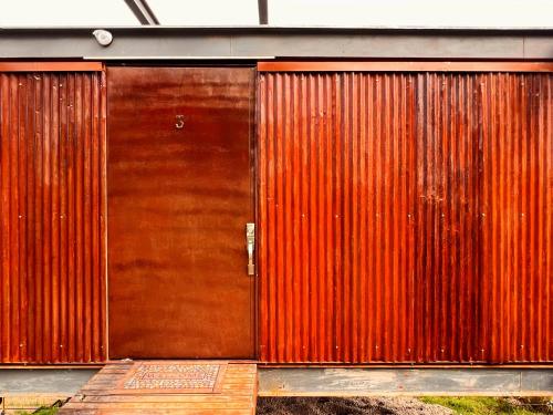 a large wooden door on a building with at Deluxe volcán Primeras suites colgantes del mundo in Baños