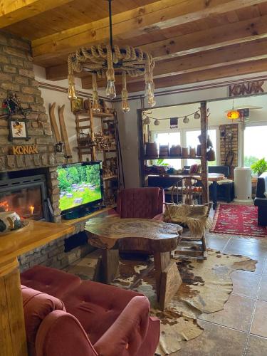 a living room with a tv and a fireplace at Konak Umoljani in Umoljani