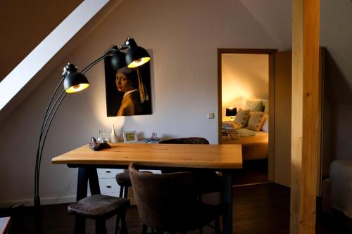 a room with a table and a lamp and a bedroom at Kungs Ferienwohnung in Cottbus