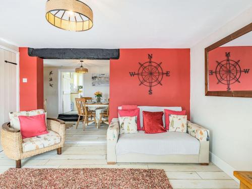 a living room with red walls and a bed and chairs at Quay End in Reedham