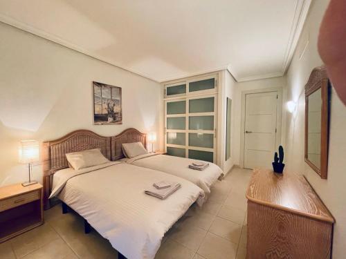 a bedroom with two beds and a desk and a window at Casa Lea Los Gigantes in Puerto de Santiago