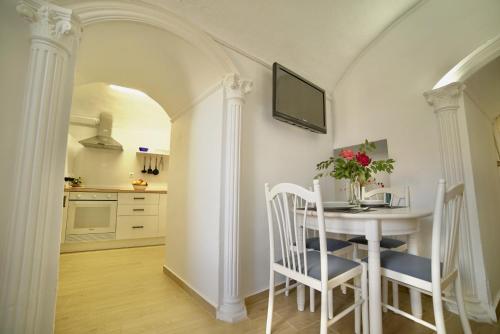 a kitchen and dining room with a table and chairs at Casa Cueva Los Mosaicos in Guadix