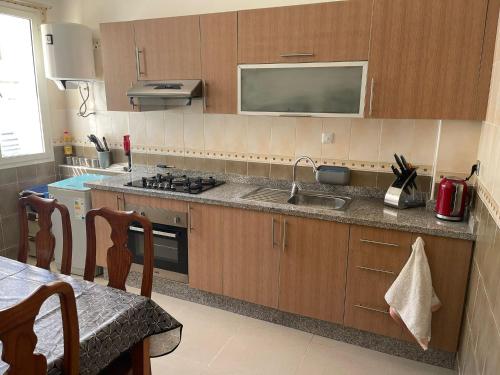 a kitchen with a sink and a stove at Magnifique appartement a louer à fnideq avec parking gratuit in Fnidek