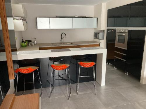 a kitchen with orange bar stools at a kitchen counter at SEVEN HOUSE in Bra