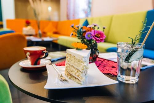 un tavolo con una fetta di torta e una tazza di caffè di Zum Löwen-Post a Trodena