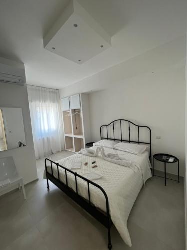 um quarto branco com uma cama grande num quarto em Campione 5 em Bari