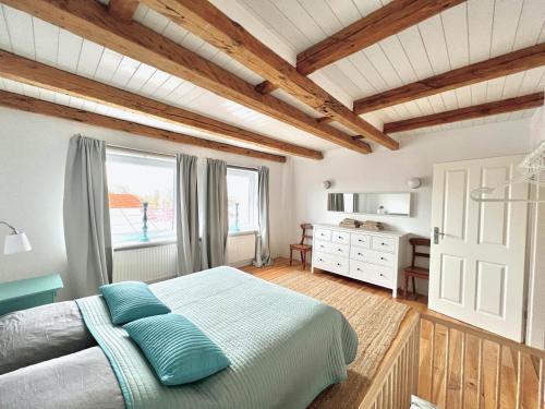 Un dormitorio con una cama con almohadas azules y una ventana en Historisches Amtshaus: BelVue, en Fehmarn