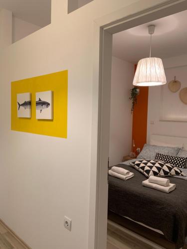 a bedroom with a bed and a yellow wall at Rooms & Apartments La Casa di Loreto in Rovinj
