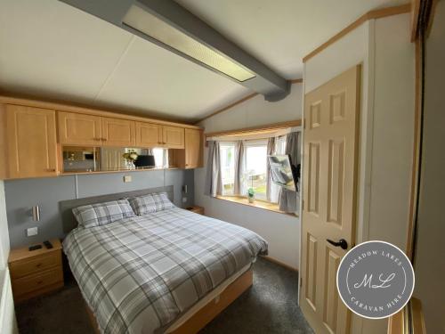 a small bedroom with a bed and a window at Golden Palm - Sherwood 472 - S472 in Skegness