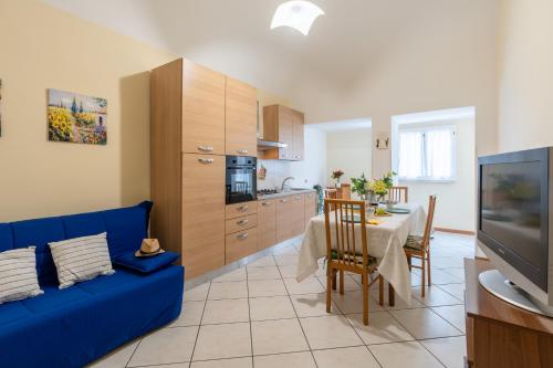 a living room with a blue couch and a kitchen at Piazza Verdi-Roseto Vacanza in Roseto degli Abruzzi