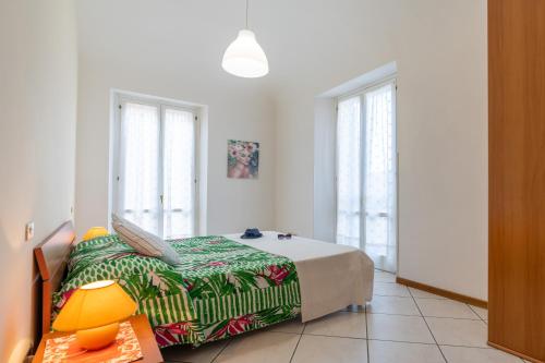 a bedroom with a bed and a table and windows at Piazza Verdi-Roseto Vacanza in Roseto degli Abruzzi