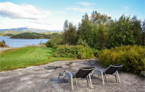 two chairs sitting on a dirt road next to a lake at Gorgeous Home In Aksdal With Kitchen in Aksdal