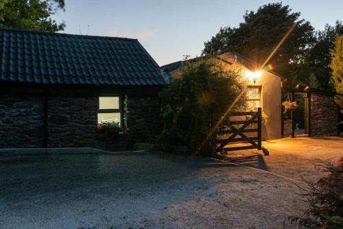 a house with a gate and a barn at The Rose Suite Kenmare in Kenmare