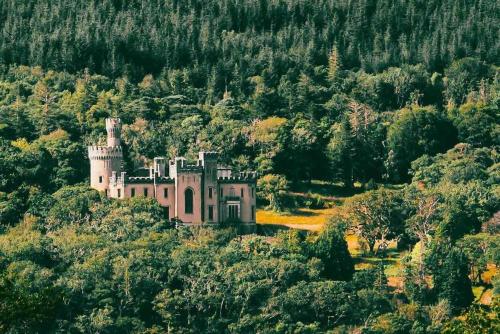 an old castle on a hill in the forest at The Rose Suite Kenmare in Kenmare