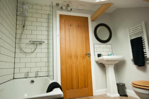 a bathroom with a tub and a toilet and a sink at Luxury three bedroom property with hot tub in West Wellow