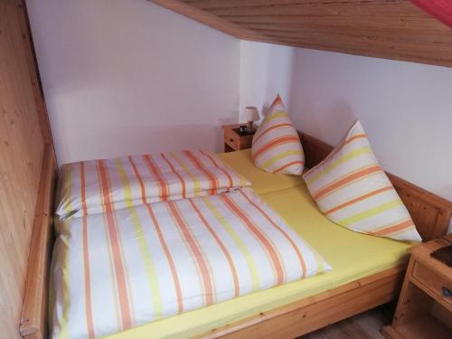 a bed in a room with two pillows on it at Ferienwohnung Emilia mit Bergblick (Osten) in Ruhpolding
