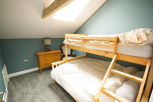 a bedroom with two bunk beds in a attic at Luxury three bedroom property with hot tub in West Wellow