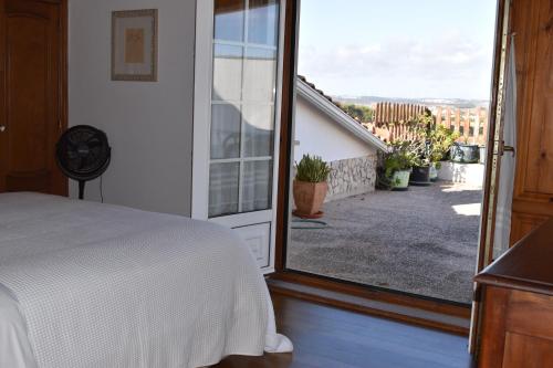 a bedroom with a bed and a large window at Casa Belo Horizonte in Lourinhã