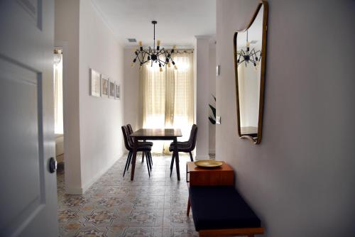 a dining room with a table and chairs and a mirror at Apartamento Turístico El Soportal de la Plaza in Daimiel
