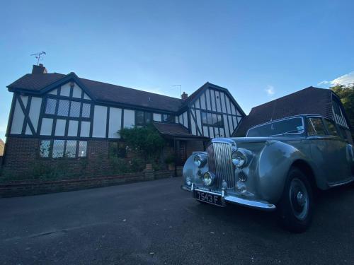 an old car parked in front of a house at The GateHouse at Stansted in Hallingbury