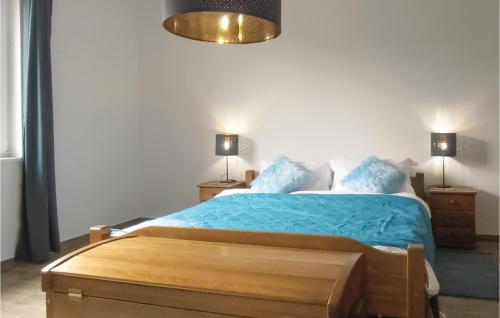 a bedroom with a bed with blue sheets and two lamps at One-Bedroom Holiday Home In Biadoliny Szlachecki in Biadoliny Szlacaheckie