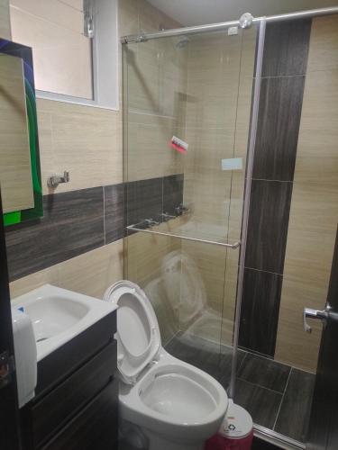 y baño con ducha, aseo y lavamanos. en Hotel Cacique en Duitama