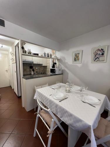 een eetkamer met een witte tafel en een keuken bij Casa di Valentina in Breuil-Cervinia