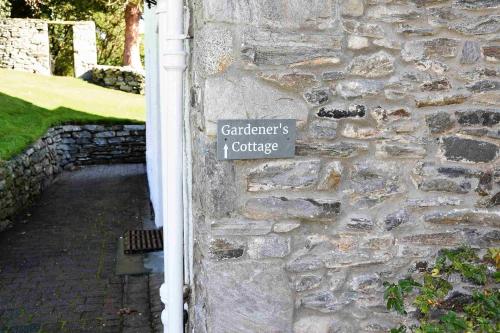 a sign on the side of a stone wall at The Gardeners Cottage in Pitlochry