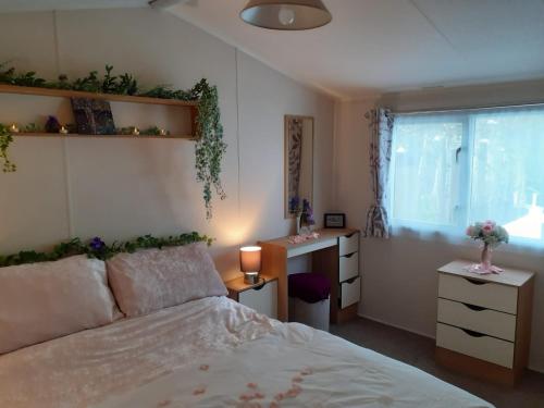 a bedroom with a bed and a desk and a window at Orchard Bank 8 in Hamworthy