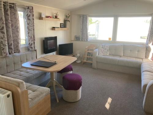 a living room with a couch and a table at Orchard Bank 8 in Hamworthy