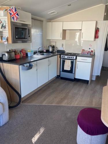 a kitchen with white cabinets and a blue stove at Orchard Bank 8 in Hamworthy
