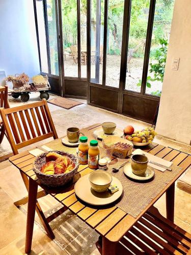 a wooden table with food on top of it at Le Mas Justin in Gordes