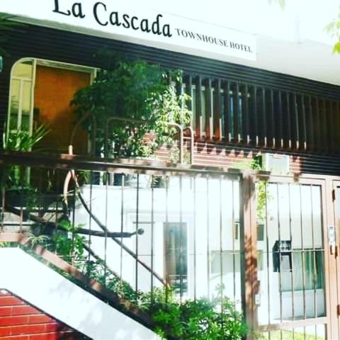 a building with a balcony with plants on it at La Cascada Townhouse Hotel in Buenos Aires