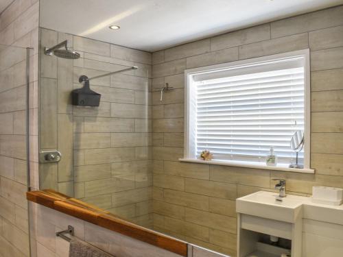 a bathroom with a shower and a sink at Sunbury Cottage in Clanfield